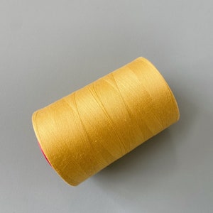 May include: A spool of yellow thread.