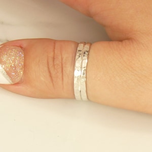 May include: A silver hammered thumb ring with a textured finish.