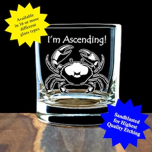 May include: A clear glass tumbler featuring a white etched graphic of a crab and the text "I'm Ascending!". The image includes a yellow starburst with the text "Available in 16 or more different glass types" and a blue starburst with "Sandblasted for Highest Quality Etching".