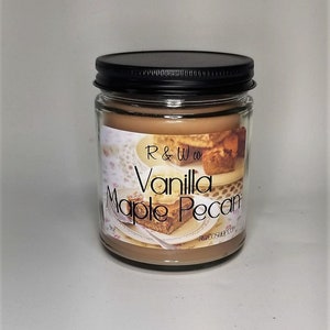 Könnte beinhalten: Eine Kerze in einem Glasgefäß mit schwarzem Deckel. Die Kerze ist braun und hat ein Etikett mit der Aufschrift "R & W co Vanilla Maple Pecan" und "rwcoshop.com".