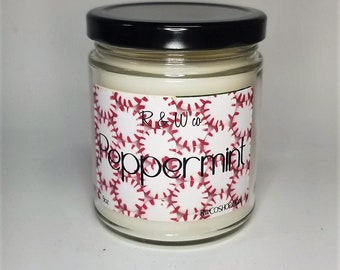 May include: A glass jar candle with a black lid. The label is white with a red and white baseball pattern and the text "R & W co. Peppermint" in black.