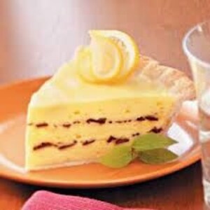 May include: A slice of lemon pie with a flaky crust and a creamy lemon filling. The pie is topped with a lemon wedge and a sprig of mint.