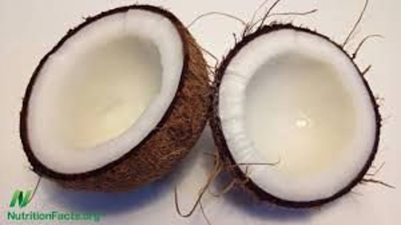 May include: Two halves of a brown coconut with the white flesh exposed. The coconut is cracked open and the inside is visible.