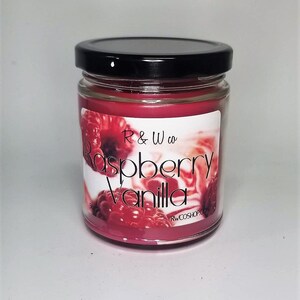 Może przedstawiać: Szklana świeca w słoiku z czarną pokrywką. Świeca jest czerwona i ma etykietę z napisem "R & W co Raspberry Vanilla" i "RWCOSHOP.COM".