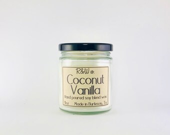 May include: A clear glass jar candle with a black lid. The label is brown with white text that reads "R&W co. Coconut Vanilla Hand poured soy blend wax 9oz Made in Burleson, Tx".