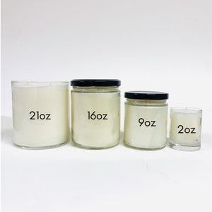 May include: Four glass candle jars in different sizes, from left to right: 21 oz, 16 oz, 9 oz, and 2 oz. The jars are clear glass with black lids and contain white candles.