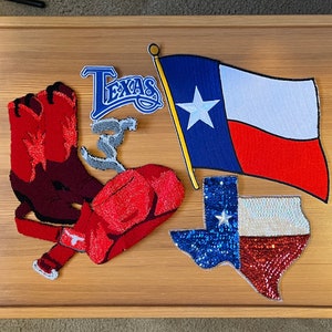 May include: A collection of five Texas-themed patches, including a cowboy boot, a cowboy hat, a Texas flag, a sequined Texas outline, and a blue and white "Texas" patch.