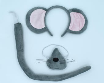 May include: A gray mouse costume set with a headband with ears, a tail, and a nose. The ears are gray with pink insides. The tail is gray and fluffy. The nose is gray with a black nose.