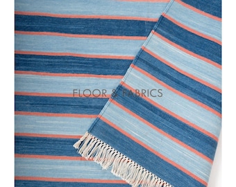 Peut inclure: Tapis à rayures bleues et corail avec bordure à franges. Le tapis présente des bandes alternées de bleu clair, bleu foncé et corail. Le texte "FLOOR & FABRICS" est visible sur le tapis.