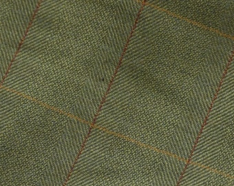 Puede incluir: Primer plano de una tela de tweed verde con un patrón de espiga y finas rayas rojas y amarillas.