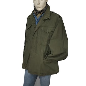 May include: A green military-style jacket with a button-up front and multiple pockets. The jacket is made of a durable cotton fabric and has a relaxed fit.