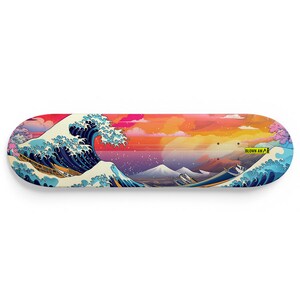 Könnte beinhalten: Ein Skateboard-Deck mit einem farbenfrohen Grafikdruck einer großen Welle, die gegen eine Bergkette kracht. Die Grafik erinnert an den berühmten japanischen Holzschnitt "Die Große Welle vor Kanagawa". Das Deck ist aus Holz und hat einen gelben Aufkleber mit dem Text "Blown Away" in der unteren rechten Ecke.