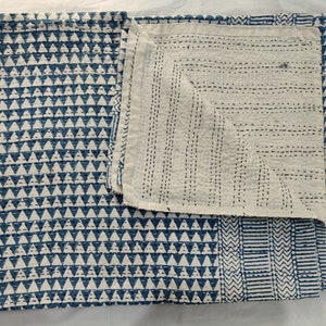 May include: A blue and white kantha quilt with a geometric pattern. The quilt is made of cotton and is hand-stitched. It is a traditional Indian textile.