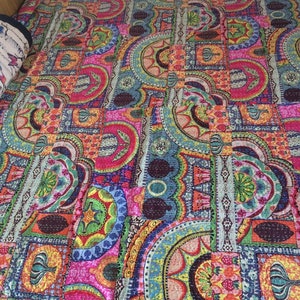 May include: A colorful kantha quilt with a patchwork design featuring geometric shapes and floral patterns in shades of pink, blue, green, orange, and yellow.