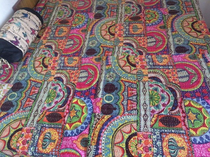 May include: A colorful kantha quilt with a patchwork design featuring geometric shapes and floral patterns in shades of pink, blue, green, orange, and yellow.