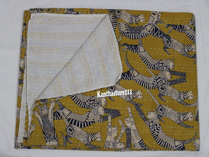 May include: A yellow kantha quilt with a white cotton backing. The quilt features a repeating pattern of black and white stylized cats.