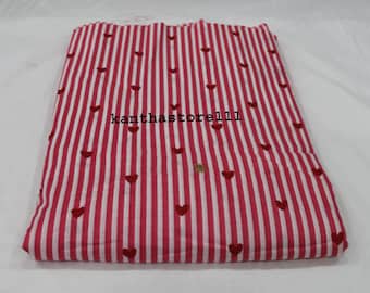 May include: A folded textile featuring a pattern of vertical red and white stripes, adorned with small embroidered red hearts scattered across the surface. The text "kanthastore111" is visible on the fabric.