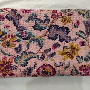 Puede incluir: Una colcha kantha rosa con un patrón floral en tonos de morado, azul y amarillo. La colcha está hecha de algodón y tiene un diseño cosido a mano.