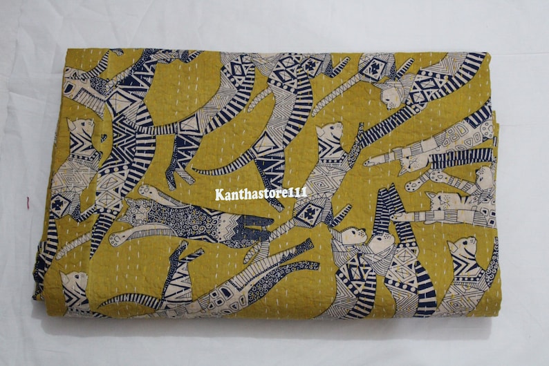 May include: A yellow fabric with a repeating pattern of black and white stylized cats. The cats are drawn in a geometric style with a variety of patterns and designs. The fabric is perfect for quilting, sewing, or crafting.