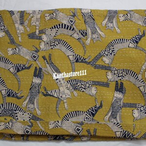 May include: A yellow kantha quilt with a pattern of black and white cats. The cats are in various poses and are outlined in black. The quilt is made of cotton and is hand-stitched.