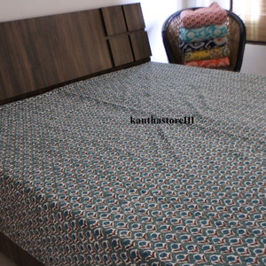 Puede incluir: Una cama con una cabecera de color marr&oacute;n oscuro y un edred&oacute;n estampado en azul y blanco. El edred&oacute;n tiene un patr&oacute;n repetitivo de peque&ntilde;as flores azules y blancas.
