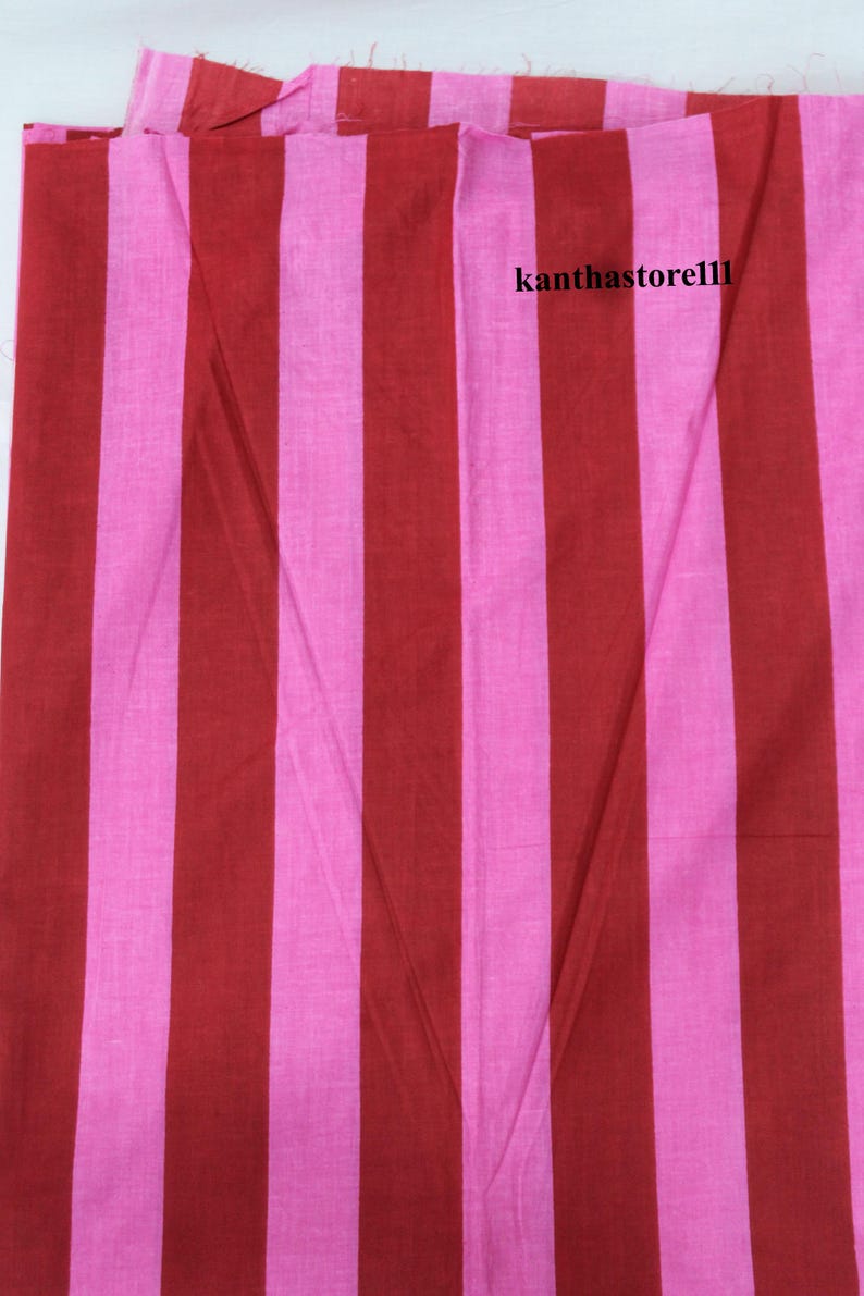 K&ouml;nnte beinhalten: Rot-rosa gestreiftes Stoff. Der Stoff hat eine gewebte Textur und ist perfekt f&uuml;r N&auml;hprojekte.