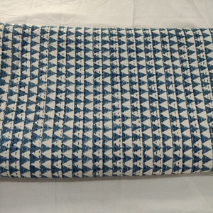 May include: A blue and white kantha quilt with a geometric pattern of triangles. The quilt is folded in half and is lying on a white surface.