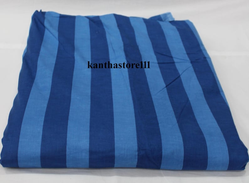 K&ouml;nnte beinhalten: Blauer und hellblauer gestreifter Stoff. Der Stoff ist in der H&auml;lfte gefaltet und hat ein Wasserzeichen mit der Aufschrift "kanthastore11".