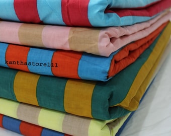 Puede incluir: Una pila de artículos de tela plegados con rayas coloridas. Los artículos muestran una gama de colores, incluyendo rojo, azul, naranja, verde y amarillo. El texto "kanthastore111" es visible en uno de los artículos. Los artículos están apilados ordenadamente.