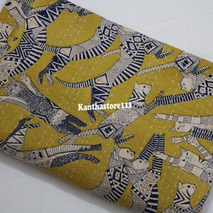 May include: Yellow fabric with a repeating pattern of stylized cats in black and white with blue accents. The fabric has a subtle texture and is perfect for quilting or crafting.