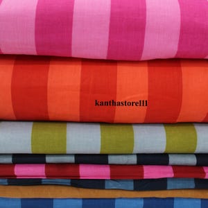 K&ouml;nnte beinhalten: Ein Stapel aus sechs verschiedenen gestreiften Stoffproben. Die Proben sind in verschiedenen Farben, darunter Pink, Rot, Orange, Gr&uuml;n, Blau und Braun. Der Stoff ist aus Baumwolle und hat ein weiches, angenehmes Gef&uuml;hl.