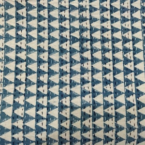 May include: A blue and white fabric with a repeating pattern of white triangles on a blue background. The triangles are outlined in black and have a textured look.