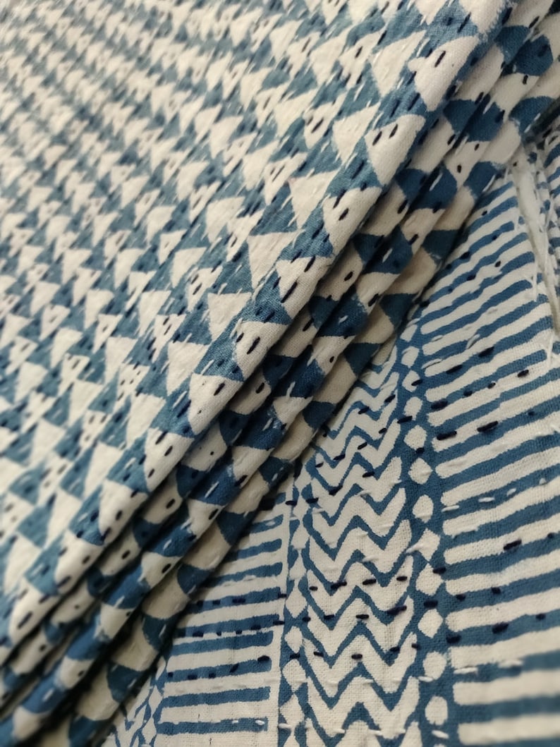 May include: Close-up of a blue and white fabric with a geometric pattern. The fabric is folded in thirds, showing the pattern on both sides.
