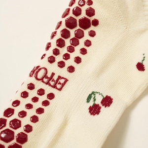 Peut inclure: Chaussettes cr&egrave;me avec un motif antid&eacute;rapant hexagonal rouge et des cerises brod&eacute;es. Le mot "EFFOR" est imprim&eacute; en rouge sur le c&ocirc;t&eacute;. Les chaussettes sont en mati&egrave;re douce et confortable.