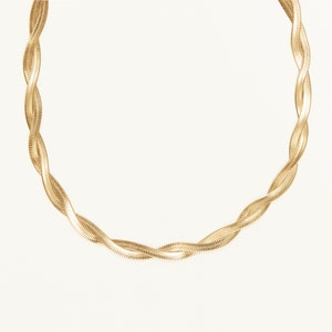 May include: A gold chain necklace with a snake chain design.