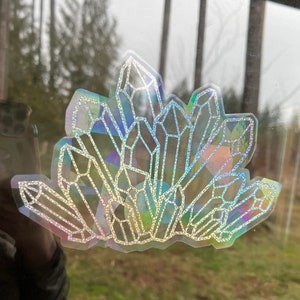 May include: A holographic sticker of a cluster of iridescent crystals, with a glittery finish.