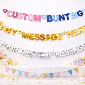 May include: A celebratory scene with three custom message banners in pink, gold, and silver, reading "CUSTOM BUNTING", "ANY MESSAGE HERE", and "YOUR CUSTOM MESSAGE". Balloons, flowers, and a teddy bear add to the festive atmosphere.