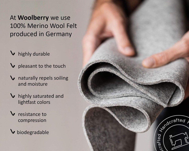 May include: A close-up of a gray wool felt fabric, folded in a hand. The text reads: "At Woolberry we use 100% Merino Wool Felt produced in Germany."  The text below the image lists the following features: highly durable, pleasant to the touch, naturally repels soiling and moisture, highly saturated and lightfast colors, resistance to compression, biodegradable.