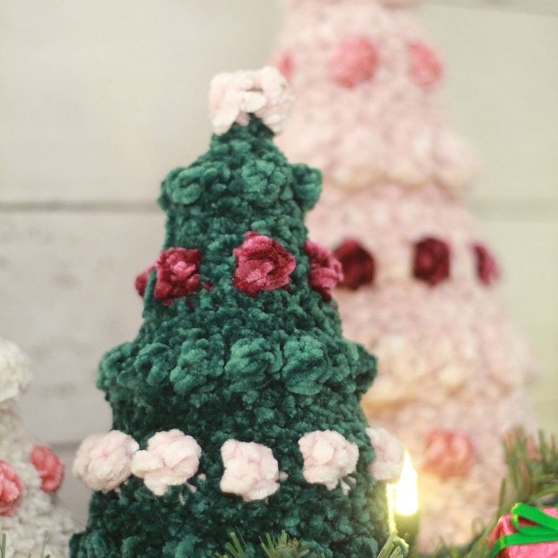Puede incluir: Un &aacute;rbol de Navidad de terciopelo verde decorado con flores de fieltro rosa y burdeos. El &aacute;rbol tiene una estrella de fieltro rosa en la parte superior.