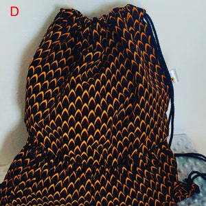 May include: A black and yellow drawstring bag with a geometric pattern. The bag has a single drawstring closure and a single strap.