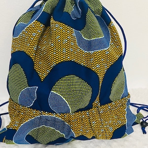 May include: A blue and yellow drawstring bag with a geometric pattern. The bag is made of fabric and has a drawstring closure.