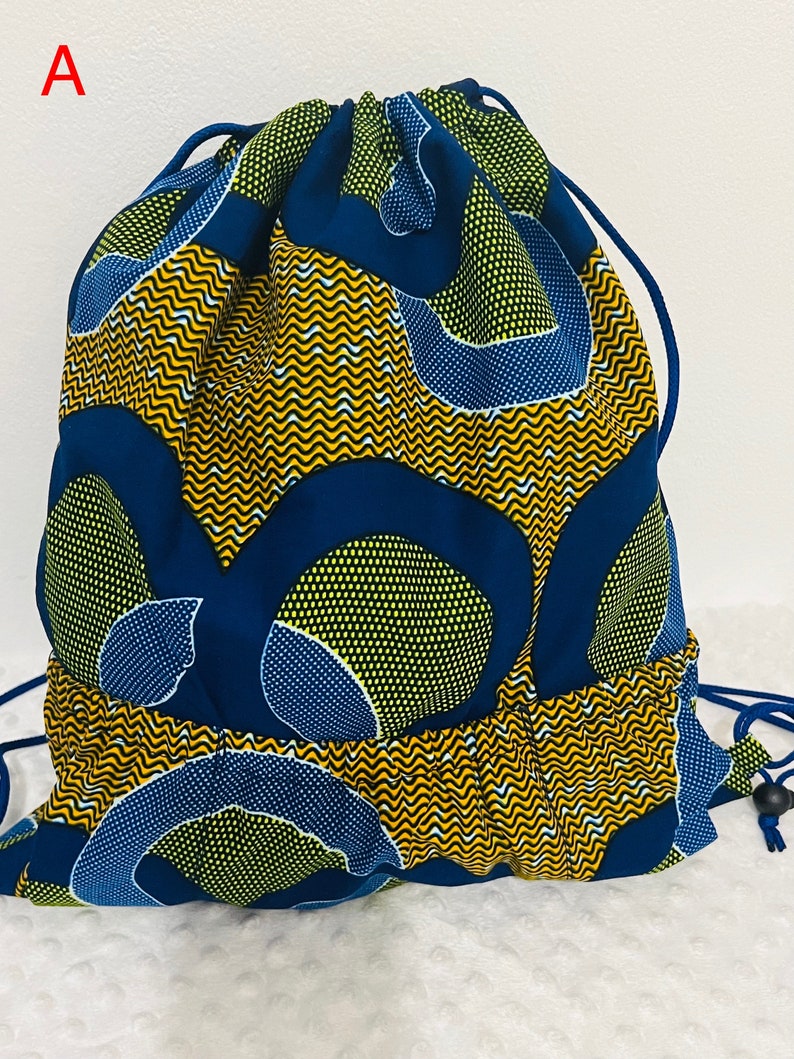 May include: A blue and yellow drawstring bag with a geometric pattern. The bag is made of fabric and has a drawstring closure.