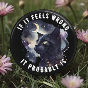 May include: A black button with the text "IF IT FEELS WRONG IT PROBABLY IS" encircling a black cat illustration. The cat is set against a starry night sky with a crescent moon.