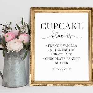 May include: A printable sign with a gold frame and white background. The sign says "Cupcake flavors" in black text with a decorative script font. The cupcake flavors listed are French Vanilla, Strawberry, Chocolate, and Chocolate Peanut Butter.