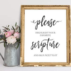 May include: A gold framed sign with white background and black text that reads "please highlight your favorite scripture and sign next to it".