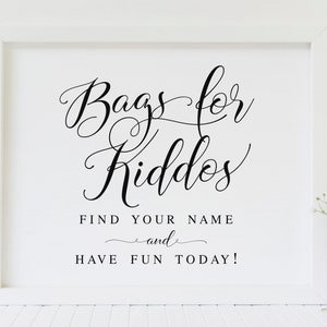 May include: White framed sign with black calligraphy that reads "Bags for Kiddos Find Your Name and Have Fun Today!"