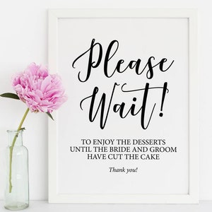 Puede incluir: Un cartel enmarcado en blanco con texto negro que dice "¡Por favor, espere! Para disfrutar de los postres, espere a que los novios corten el pastel. ¡Gracias!"