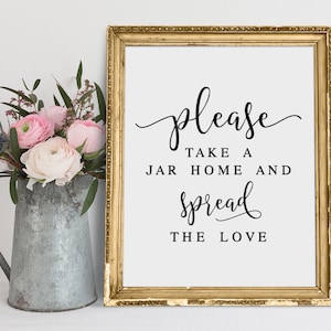 Può includere: Un cartello dorato incorniciato con il testo "Per favore, prendi un barattolo a casa e diffondi l'amore" in calligrafia nera.