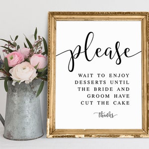 Puede incluir: Un cartel con marco dorado, fondo blanco y texto negro que dice "por favor espere para disfrutar de los postres hasta que la novia y el novio corten el pastel gracias".