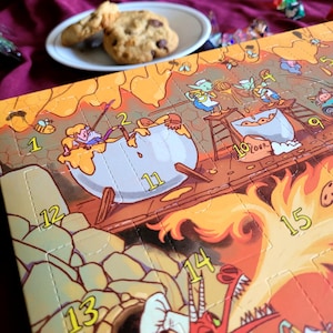 May include: A rectangular cardboard advent calendar with a colorful illustration of fantasy creatures baking. The scene features numbered perforated doors from 1 to 15, depicting characters stirring large pots and a dragon breathing fire.